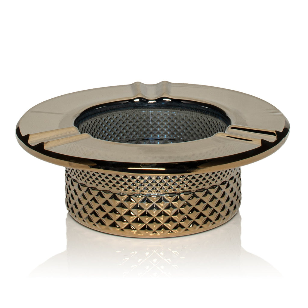 Decorative chrome ashtray with textured design on a white background