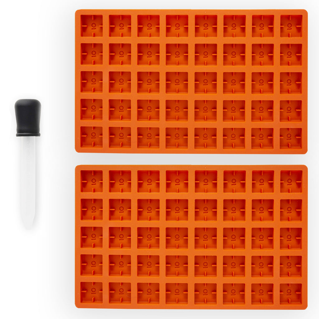 Two orange silicone molded trays on a white background